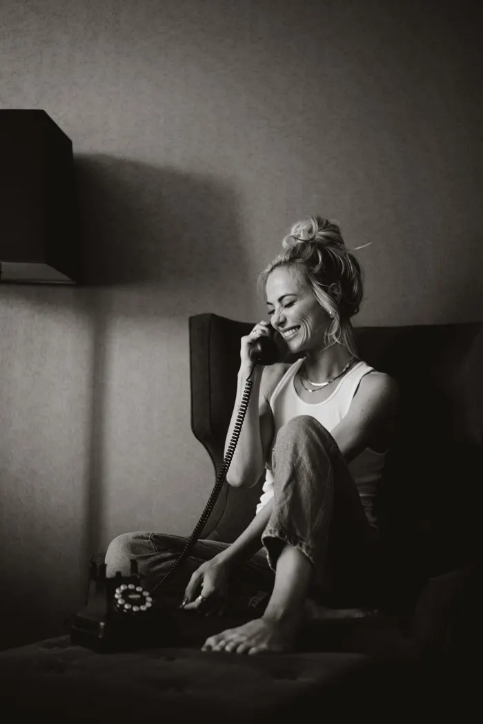 Tyler Tanner mid-conversation on a rotary phone, black and white.